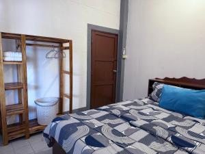 een slaapkamer met een bed met een blauw en wit dekbed bij Baboo Guesthouse in Chiang Dao