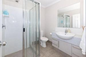 een badkamer met een glazen douche en een wastafel bij Peaceful on Percy West End Townsville in North Ward