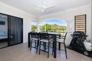 een eetkamer met een tafel en stoelen en een grill bij Peaceful on Percy West End Townsville in North Ward +10 foto's