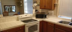 a kitchen with a stove top oven next to a sink at Historic Reno Home in Reno +14 photos