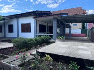 een wit huis met een dak bij Baboo Guesthouse in Chiang Dao
