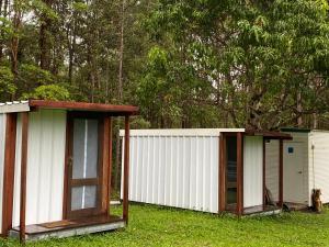 zwei kleine Gebäude, die im Gras in einem Hof stehen in der Unterkunft Soulhaven at Bentley in Bentley