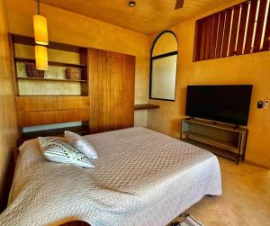 een slaapkamer met een bed en een flatscreen-tv bij Modern 1BR House by Parque La Plancha in Mérida