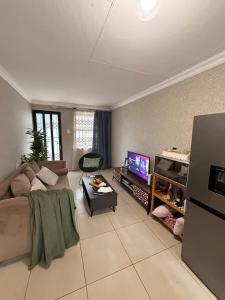 a living room with a couch and a tv at Shayas Haven in Thohoyandou