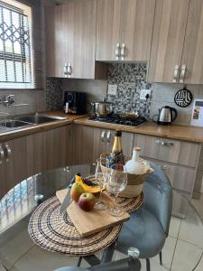 a kitchen with a glass table with two wine glasses at Shayas Haven in Thohoyandou