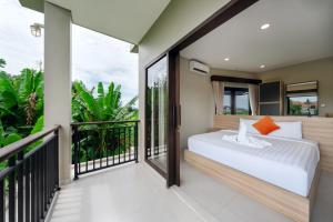 a bedroom with a bed on a balcony at Uma Dauh Villa - Cemagi in Munggu
