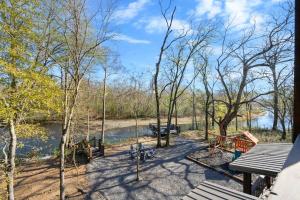 a picnic table and benches next to a river at Chillax Inn The River For 19 in Broken Bow