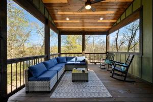 a screened in porch with a blue couch and chairs at Chillax Inn The River For 19 in Broken Bow +42 photos