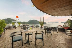 een patio met stoelen en tafels en uitzicht op het water bij Beka Cruise 