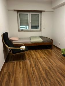 a room with a bed and a chair and a window at MALÔ - Queluz in Queluz