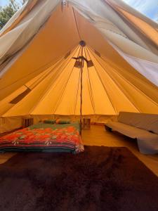 een tent met een bed en een bank in een kamer bij Glamping Peumayen Chucao in Llanquihue