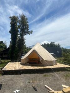 een witte tent bovenop een houten terras bij Glamping Peumayen Chucao in Llanquihue