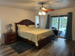 ein Schlafzimmer mit Bett und Deckenventilator in der Unterkunft Paradise in the forest in Lehigh Acres + 61 Fotos