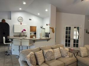 ein Wohnzimmer mit Sofa und eine Küche in der Unterkunft Paradise in the forest in Lehigh Acres