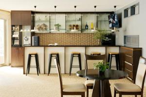 a kitchen with a bar with stools and a table at Oakwood Residence Aoyama Tokyo in Tokyo