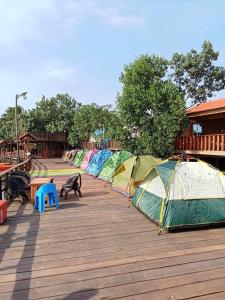 a row of tents on a wooden deck at Chi Phat River lodge in Chi Phat