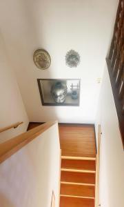 eine Treppe mit Holzstufen und zwei Bildern an der Wand in der Unterkunft 富士見旅館206 in Fujiyoshida
