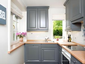 una cucina con mobili blu e un lavandino di Drosselhues-Sued a Kampen