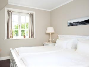 una camera da letto bianca con un letto e una finestra di Drosselhues-Sued a Kampen