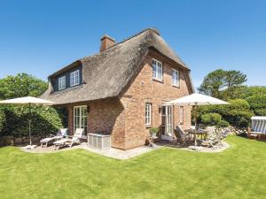 una grande casa di mattoni con ombrelloni nel cortile di Drosselhues-Sued a Kampen