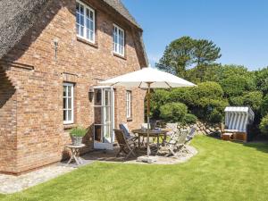 un patio con un tavolo e un ombrellone di Drosselhues-Sued a Kampen Altre 5 foto