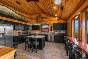 a kitchen with black cabinets and a wooden ceiling at Soaring Views Lodge in Sevierville
