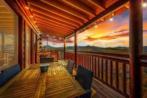 a wooden table on a balcony with a sunset at Soaring Views Lodge in Sevierville