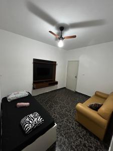 een woonkamer met een bank en een plafondventilator bij Residencial Parque Santa Bárbara in Campinas