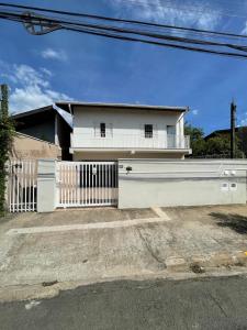 een wit hek voor een wit huis bij Residencial Parque Santa Bárbara in Campinas