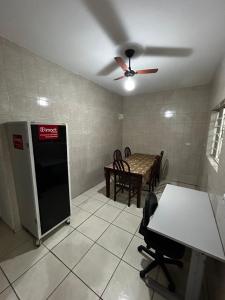 een woonkamer met een plafondventilator en een tafel bij Residencial Parque Santa Bárbara in Campinas