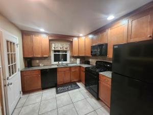 a kitchen with wooden cabinets and a black refrigerator at Lansdowne Gem in Lansdowne +21 photos