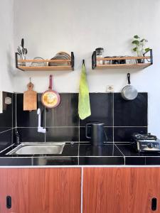 una cucina con lavandino e piano di lavoro nero di SleepOver BDI2 a Wonosobo