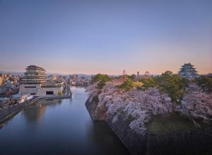 uitzicht op een rivier met een stad en gebouwen bij Espacio Nagoya Castle in Nagoya
