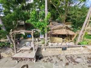 a model of a bamboo house with a table and chairs at Kamp Tapik - Sibaltan in El Nido