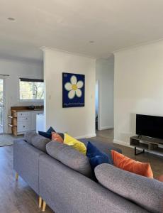 a living room with a gray couch with colorful pillows at Happy Mountain House in Blackheath