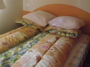 a bed with pillows and a comforter on it at Mobil-home confortable avec terrasse à La Couarde - API-1-52-1305 in Saint-Nicolas des Eaux