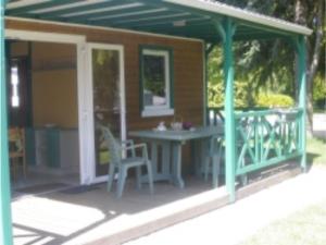 een afgeschermde veranda met een tafel en stoelen bij Chalet avec Terrasse pour 4 Pers. - API-1-52-1306 in Saint-Nicolas