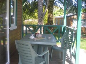 een tafel en stoelen op de veranda van een huis bij Chalet avec Terrasse pour 4 Pers. - API-1-52-1306 in Saint-Nicolas +5 foto's