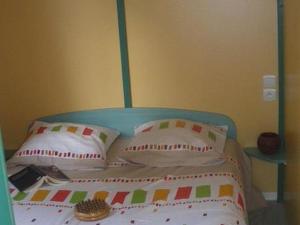 een bed met een blauw hoofdeinde en kussens bij Chalet avec Terrasse pour 4 Pers. - API-1-52-1306 in Saint-Nicolas