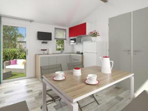 eine Küche und ein Esszimmer mit einem Holztisch in der Unterkunft Mobil-home 27m² à Saint-Gérons avec terrasse - API-1-52-1316 in Saint-Étienne-Cantalès + 12 Fotos