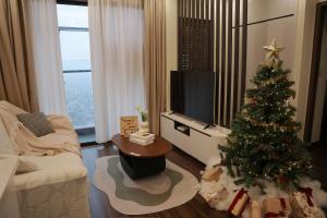 a living room with a christmas tree and a television at Hoàng Huy Commerce Võ Nguyên Giáp Enny Homestay in An Khê