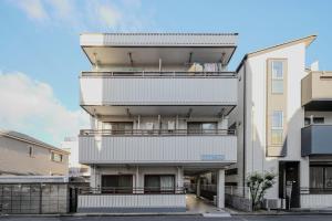 ein weißes Gebäude mit Balkonen an der Seite in der Unterkunft 3 min JR Direct to Skytree Asakusa Shinjuku Sea Heim in Tokio