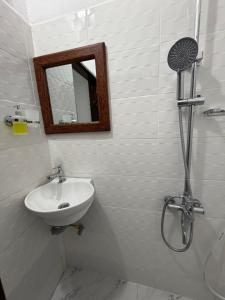 a bathroom with a sink and a mirror and a shower at Nashu House Stone Town in Ngambo