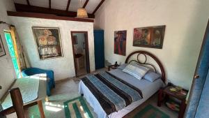 a bedroom with a bed and paintings on the wall at Atelie Hospedagem in Palhoça
