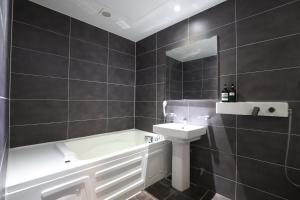 un bagno con un lavandino, una vasca da bagno e un lavandino di Nampo MGM Hotel a Busan Altre 35 foto
