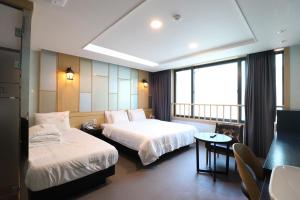 una camera d'albergo con due letti e un tavolo di Nampo MGM Hotel a Busan