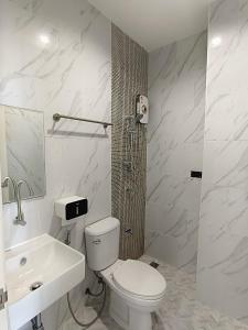 une salle de bains blanche avec toilettes et lavabo dans l'établissement Airport Stay Phuket Zz, à Nai Yang Beach