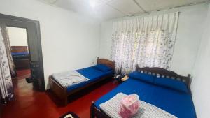 a bedroom with two beds and a window at Liptora Homestay in Bandarawela +4 photos