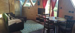 een kleine woonkamer met een tafel en een keuken bij Domo rústico Puacura Castro- Dalcahue in Dalcahue