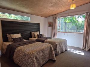 een slaapkamer met twee bedden en een raam bij Peony Summer Paradise in Halswell